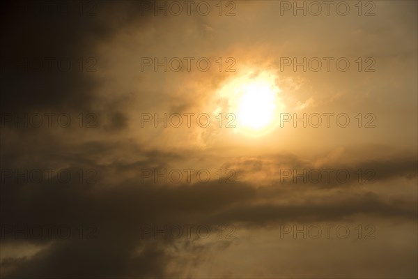 Sun behind clouds and brownish ash and gas clouds of the Holuhraun fissure eruption