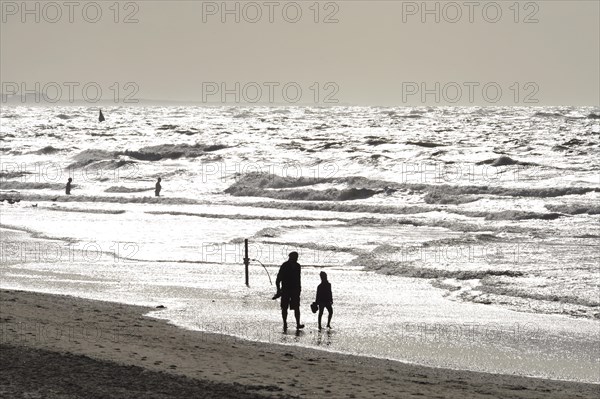 Man and child walking on the beach