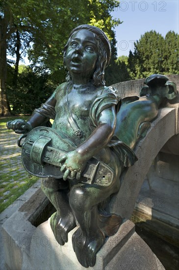 Child's sculpture with musical instrument and fish fin on Minnesangerbrunnen fountain
