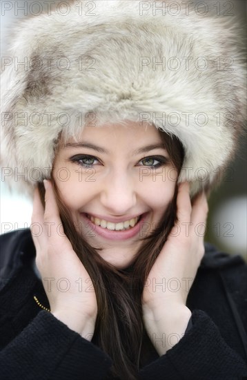 Smiling young woman wearing a fur hat