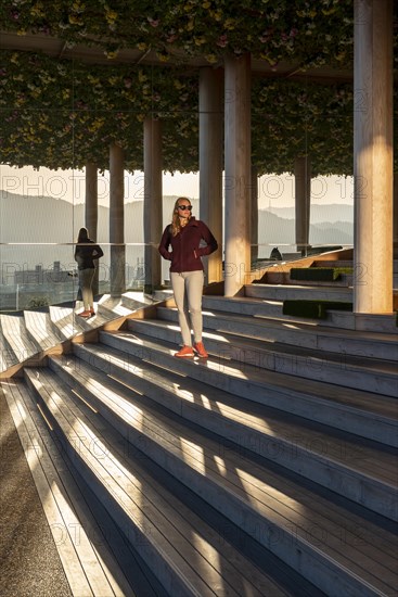 Young woman standing on stairs on panoramic roof