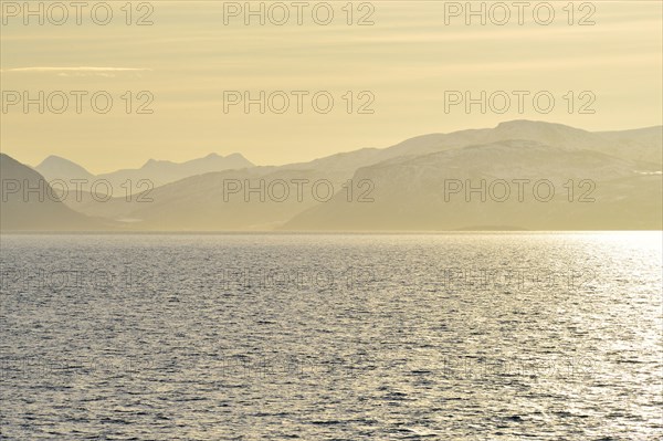 Glistening water and the mountains of Hinnoya in the yellow morning light