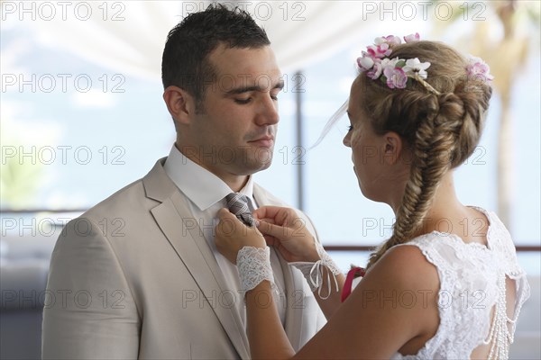 Bride adjusting the groom's tie