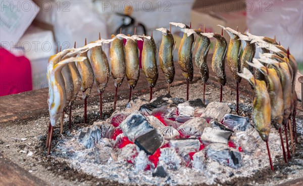 Grilled fish over fire at a food stall