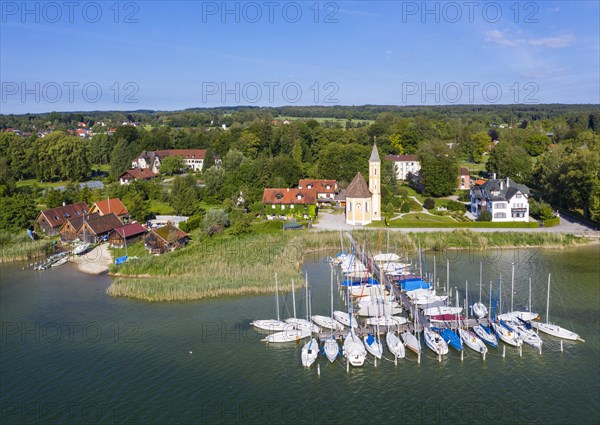 Boat landing stage in the Lake Ammer and church St. Alban