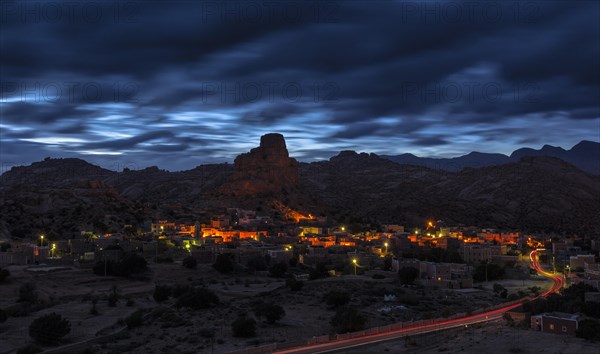 Small village of Aguard Oudad with brightly painted houses in front of the rock Chapeau Napoleon