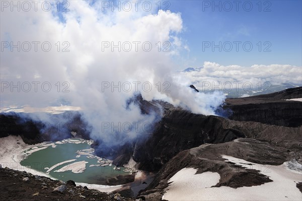 Volcanic crater with crater lake and a hot water vapour cloud