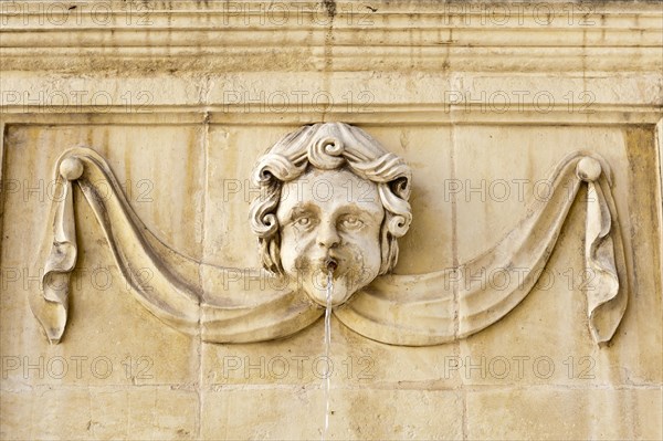 Baroque-style face on a fountain at St. John's Co-Cathedral