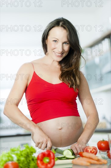 Pregnant woman posing with vegetables