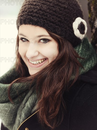 Smiling young woman wearing hat and scarf in winter