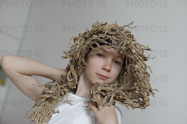 Girl wearing a wig made from cardboard packaging