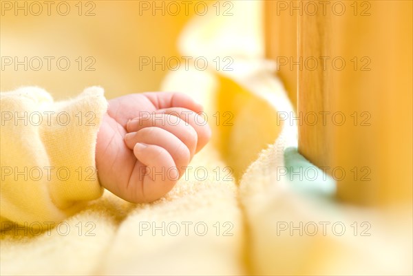 Clenched baby hand in baby bed