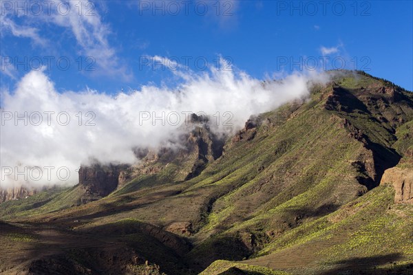 Wispy clouds over a mountain ridge