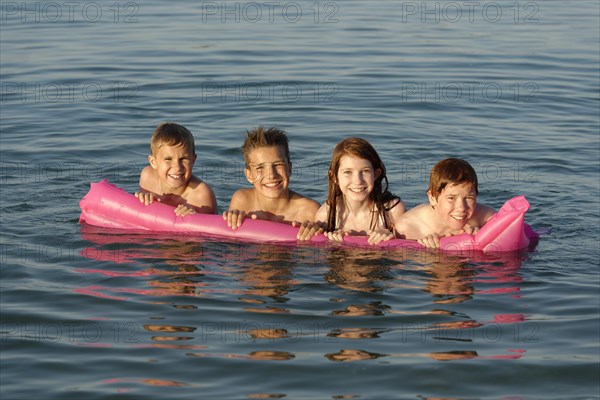 Children on a lilo in the sea