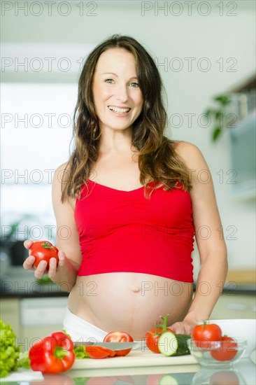 Pregnant woman posing with vegetables