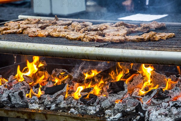 Steaks on a charcoal grill with flames