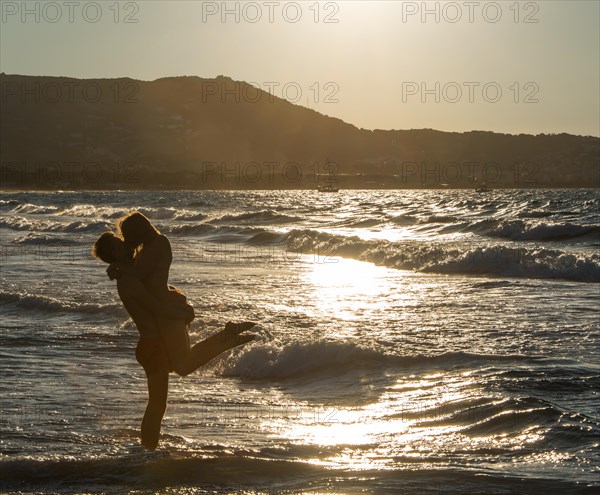 Young couple on the beach kissing