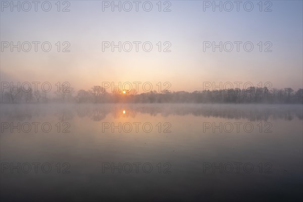 Sunrise in the fog at a pond