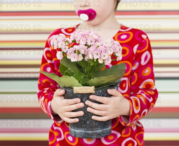 Girl holding flower in flowerpot