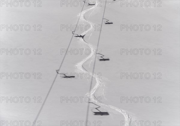 Ski track in deep snow with shadows from a chair lift