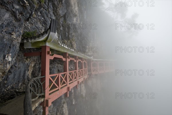 Covered hiking trail on a cliff in fog