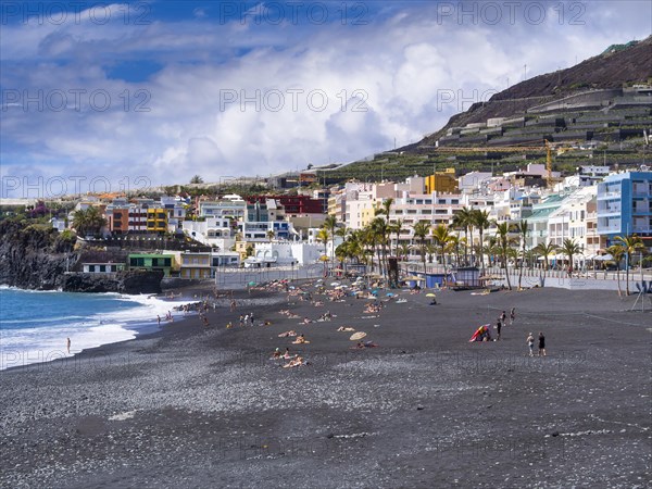 Tourists on the black beach of Puerto Naos