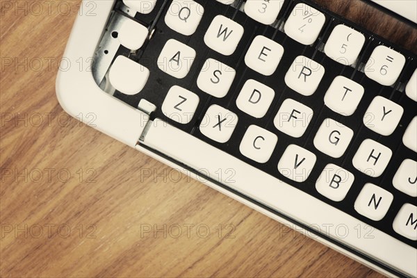 Detail view of the keys on an old fashioned typewriter from the 1970s on a wooden table