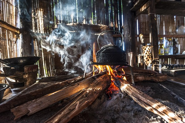 Kettle over an open fire in a kitchen made of bamboo