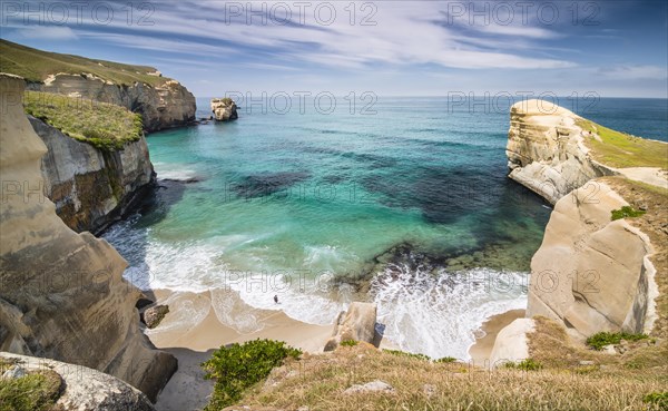 Solitary person on the rocky cliffs of the Pacific coast in the distance