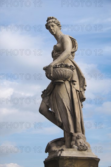 Seasons statue on Ponte Santa Trinita bridge spanning the river Arno
