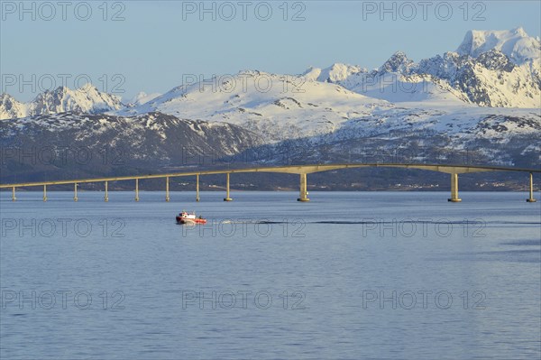 Red boat in front of Hadsel Bridge across the strait