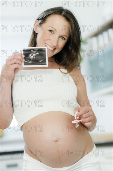 Pregnant woman holding an ultrasound image