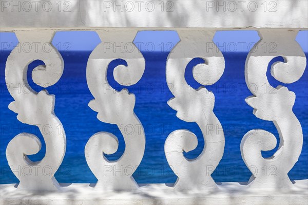 White ornate railing with views of the sea