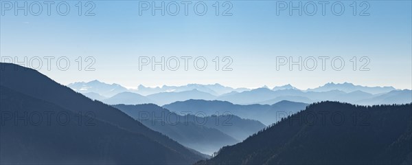 Mountain chains one behind the other in backlight