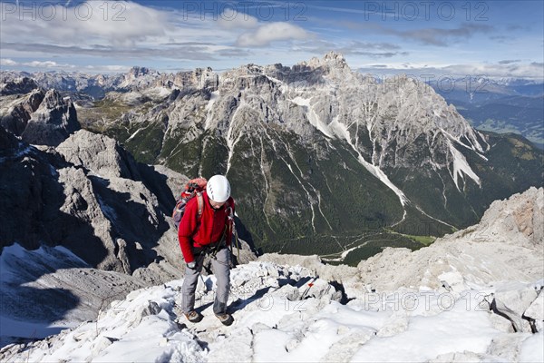 Mountaineer during the ascent over the Croda Rossa via ferrata on the Sesto Croda Rossa in the Dolomites