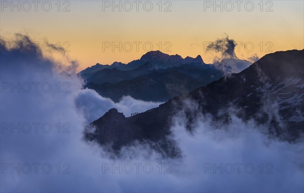 Four climbers on the mountain edge heading to Quintino Sella Hut