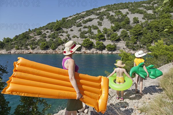 Woman and children on their way to the beach in a bay