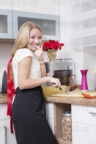 Young woman making Christmas cookies at home