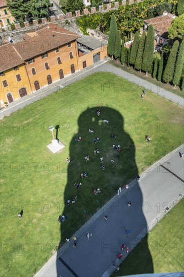 Tourists cooling off in the shade of the Leaning Tower of Pisa