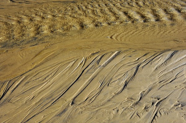 Draining sea water leaving traces in the sand on the beach