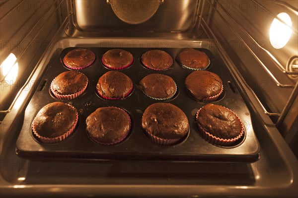 Oreo brownie cupcakes on a baking tray in the oven