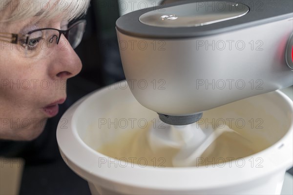 A wide-eyed woman looking at her kitchen machine