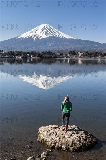 Young woman standing on stone in water