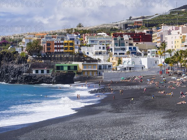 Tourists on the black beach of Puerto Naos