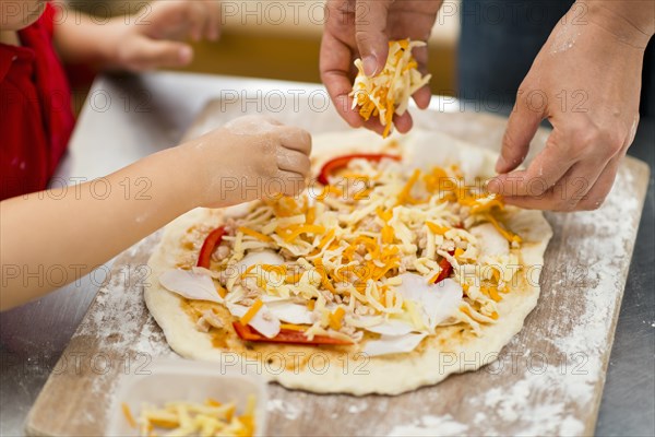 Child and mother making pizza