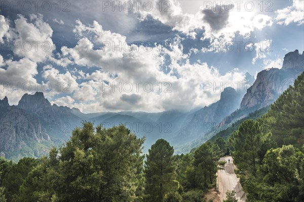 Street through a valley with cliffs in clouds