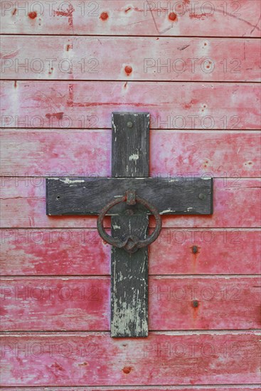 Weathered cross on a wooden wall