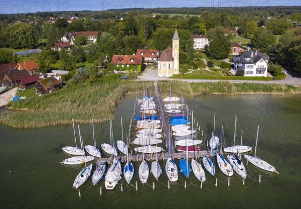 Boat landing stage in the Lake Ammer and church St. Alban