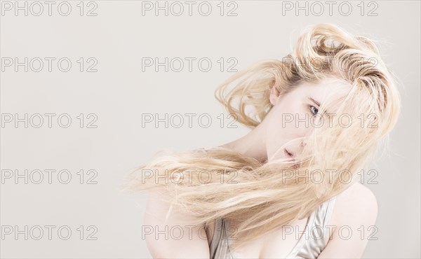 Woman with long blond hair covering her face