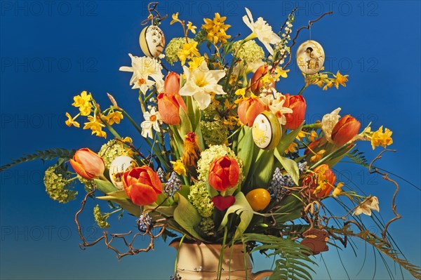 Easter bouquet in a vase against blue